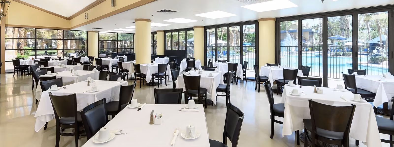Alexis Gardens Restaurant dining room with white tablecloths and pool views