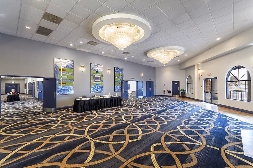 Ballroom foyer with chandeliers and a reception table