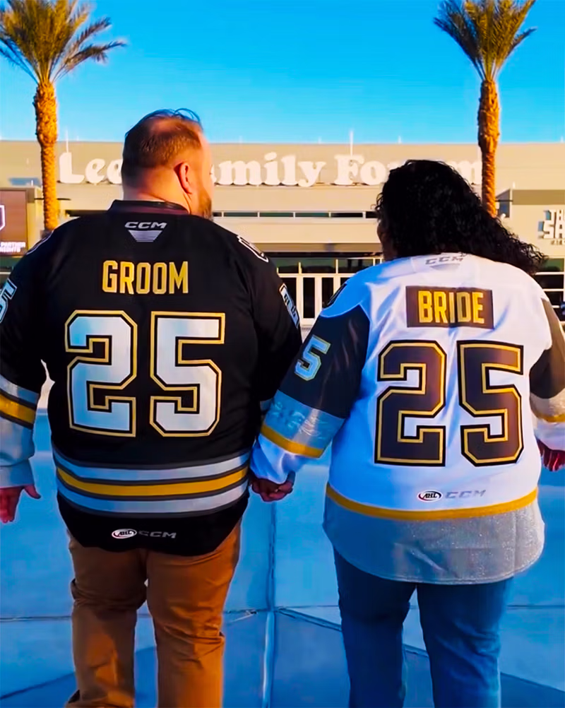 Bride and groom in custom hockey jerseys at Lee's Family Forum
