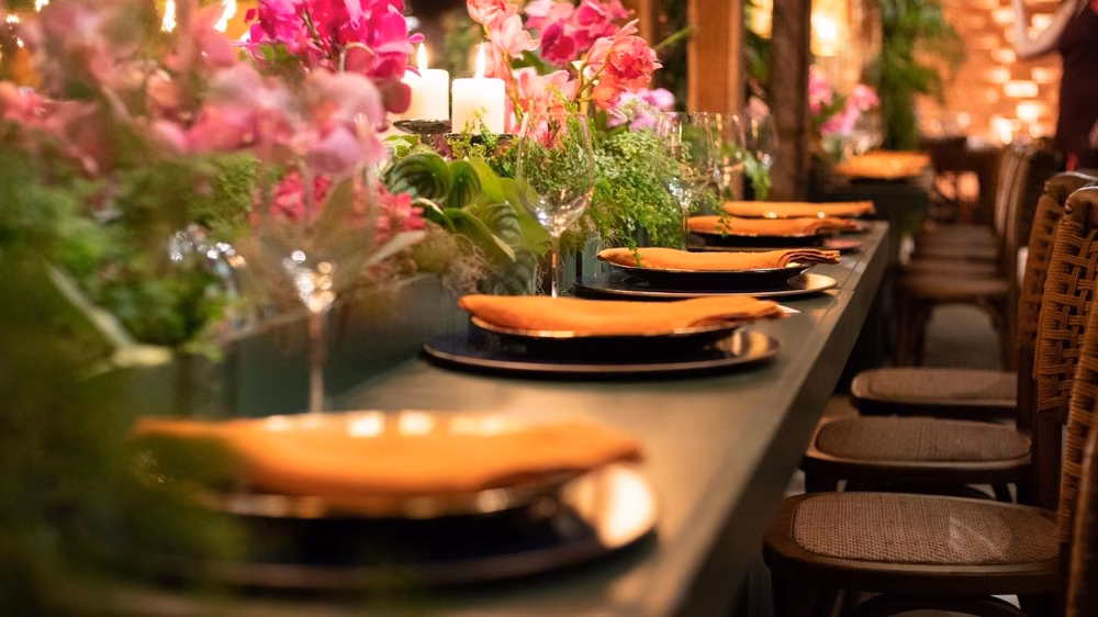 Vibrant orchid centerpiece on a reception table with guests mingling in the background