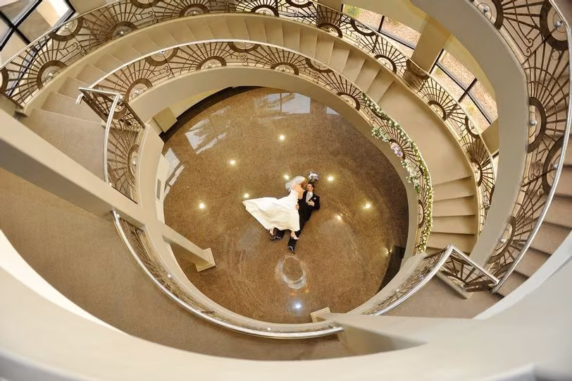 Overhead view of a couple on the marble floor inside the spiral staircase