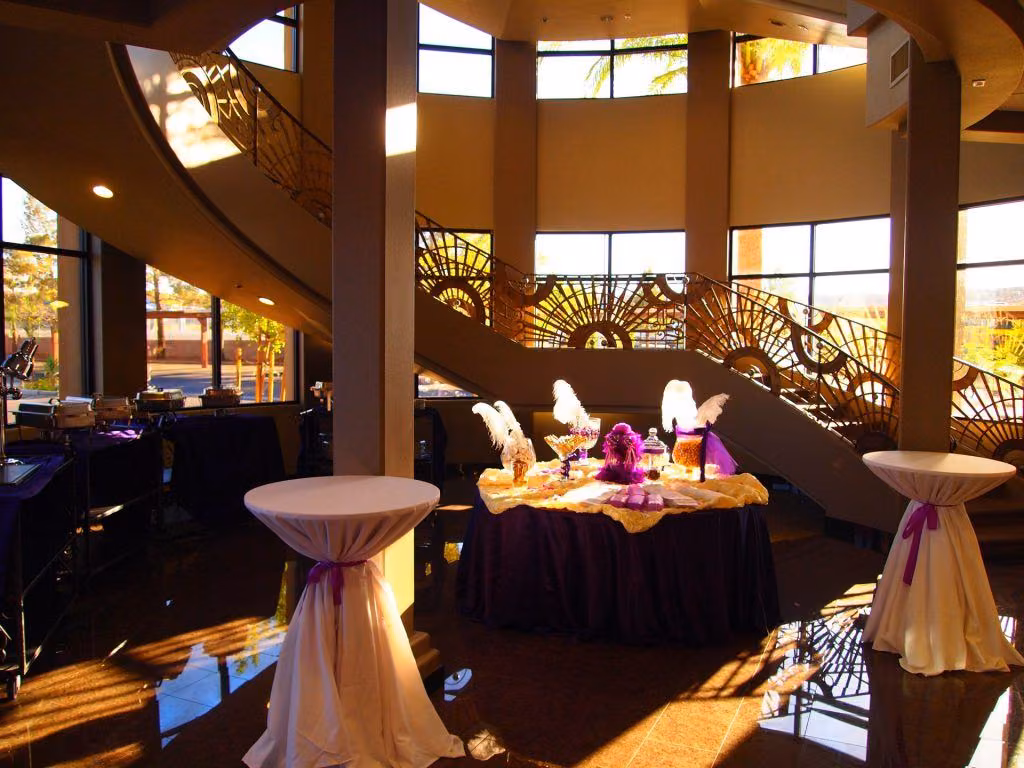 Dessert table and cocktail tables beneath the grand staircase