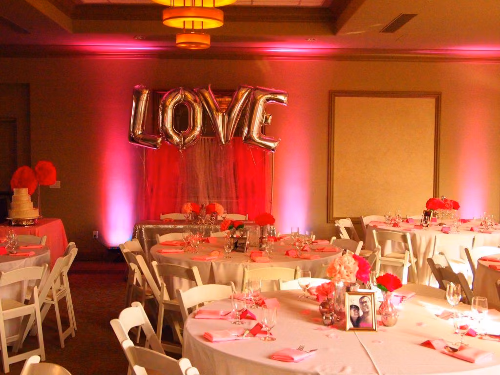 Reception with LOVE balloon letters and pink and red uplighting